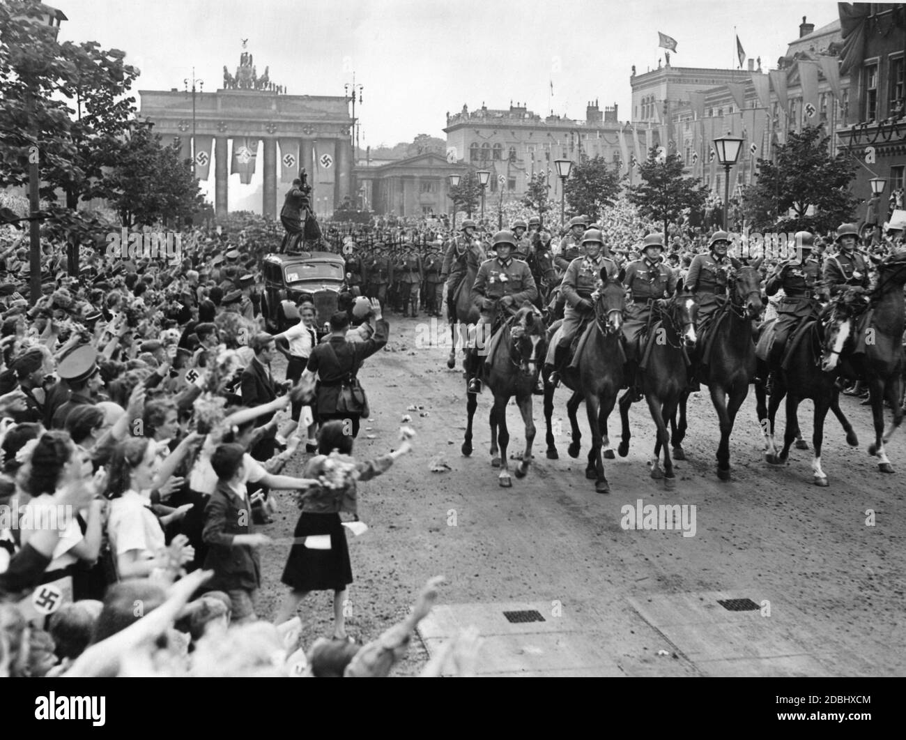 Victory parade of the Wehrmacht on Unter den Linden in Berlin after the end of the fighting in France. In the background, the Brandenburg Gate. Stock Photo
