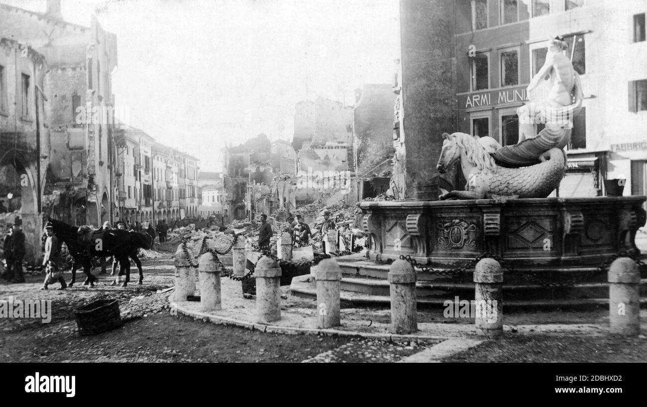 At the Isonzo front: German or Austro-Hungarian troops move past the memorial fountain in the Italian town of Conegliano. In the background the debris of destroyed buildings. Stock Photo