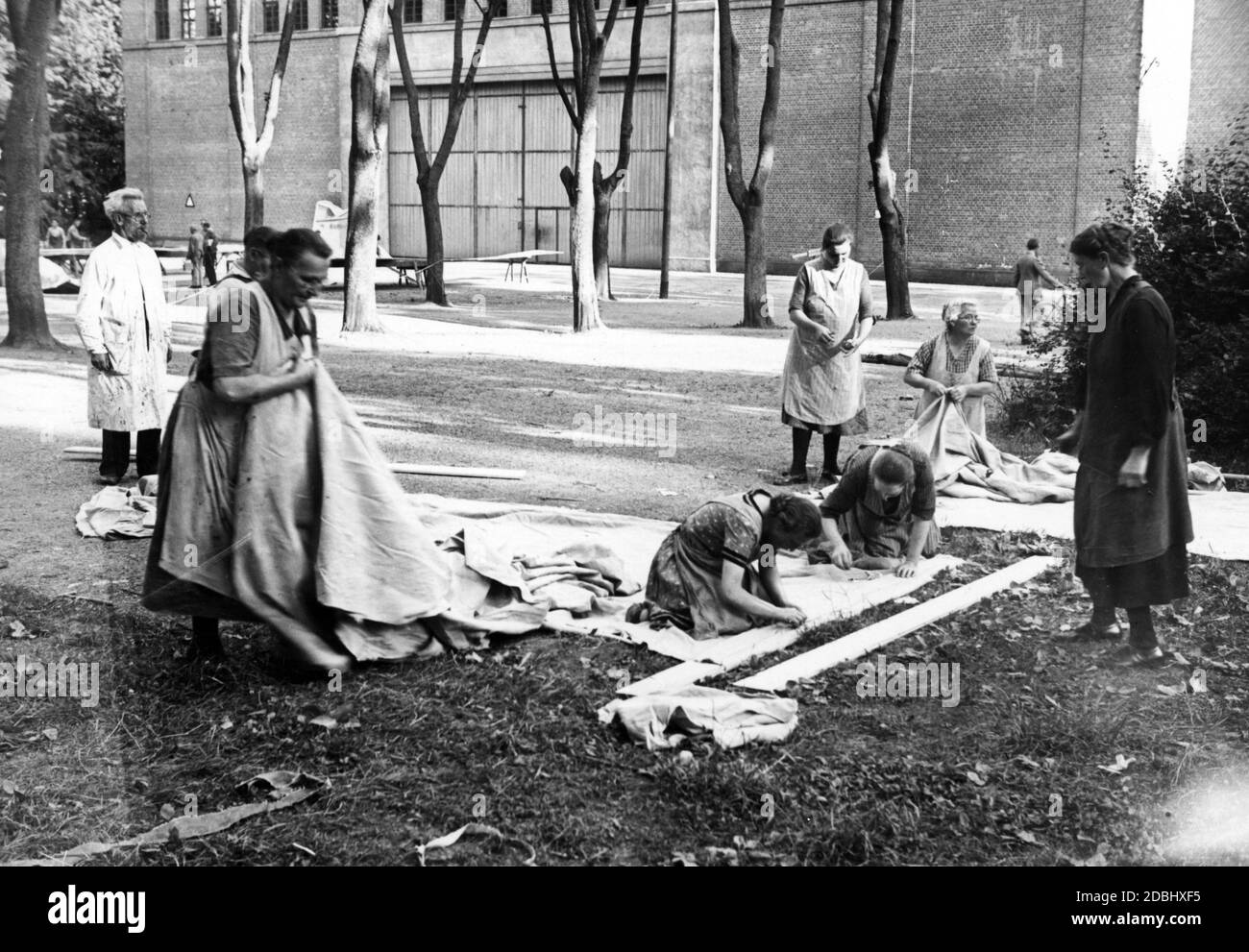 Women sew cloths for the stage design outside the Festspielhaus. Stock Photo