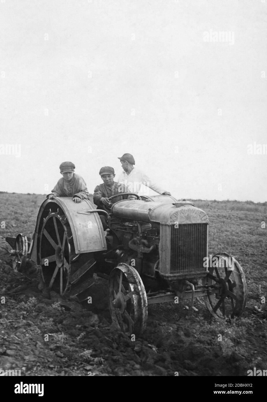 First use of a newly delivered tractor on a kolkhoz (collective farm). Stock Photo