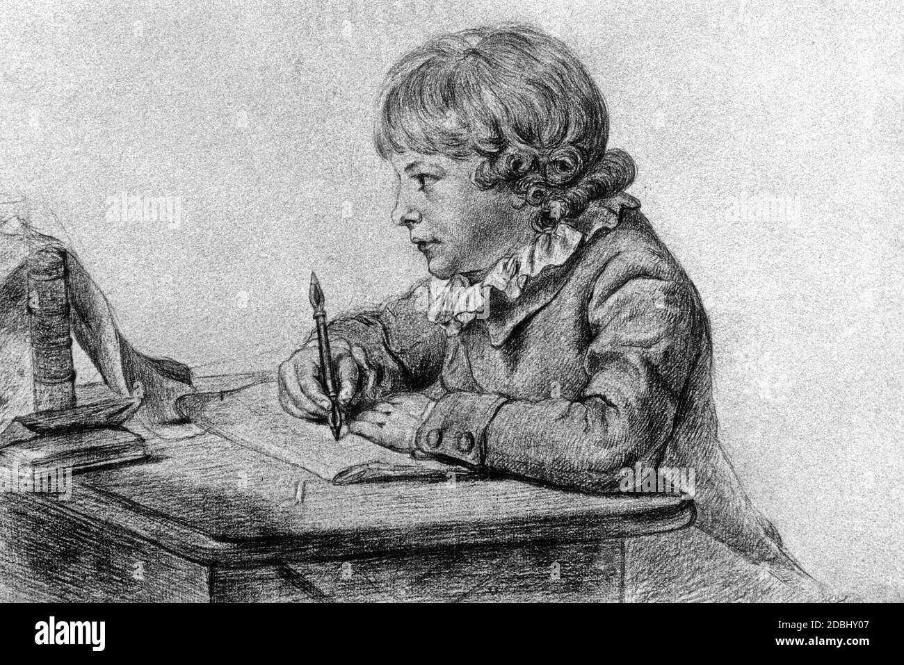 A boy is doing his homework. He writes something with a fountain pen. Around 1850. Stock Photo