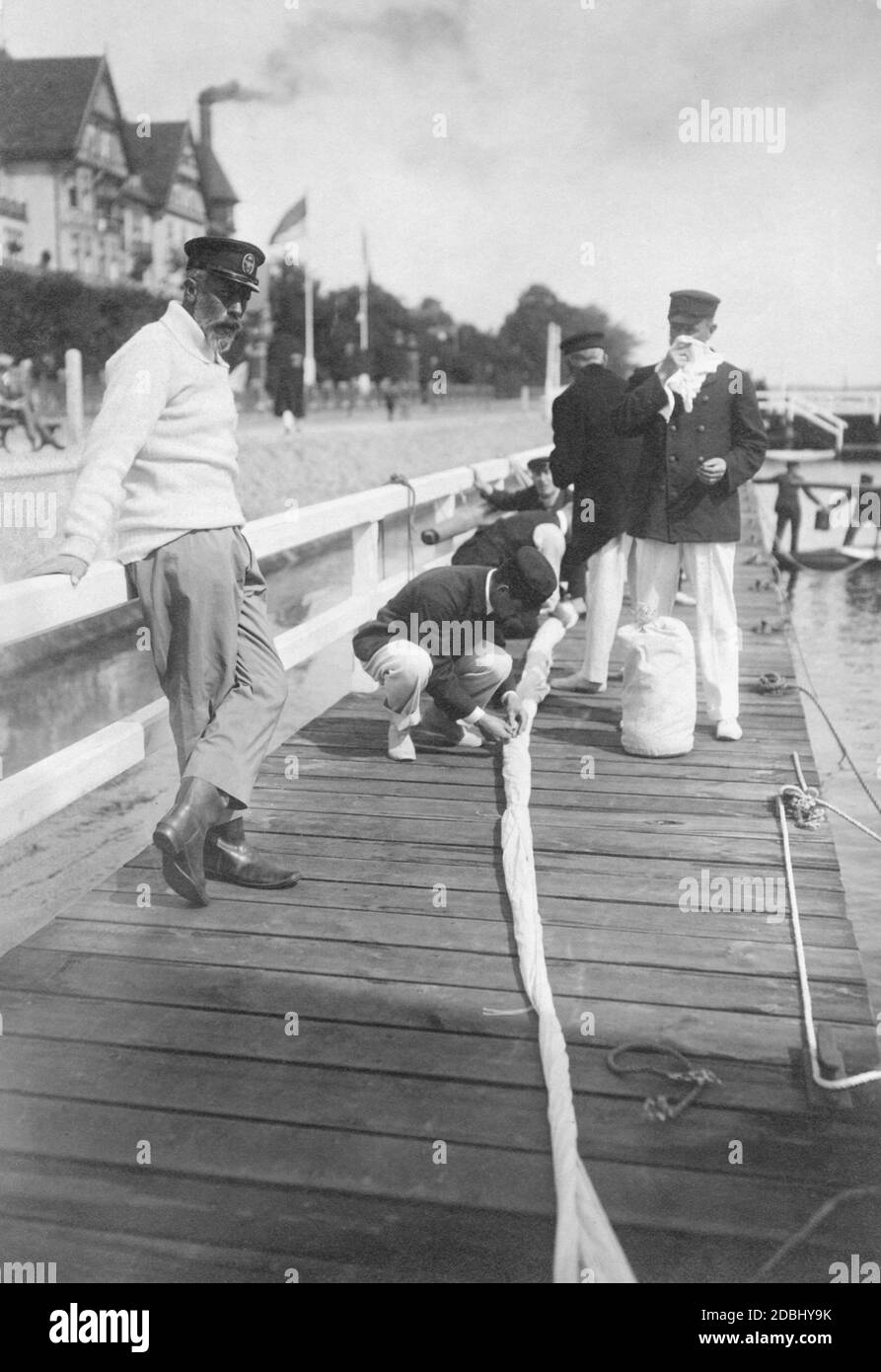 'Prince Henry of Prussia (left) watches the crew of the sailing yacht ''Tilly XVII'' at work on the bridge of the Kaiserlicher Yacht-Club  (''Imperial Yacht Club'') after a race. Henry of Prussia attended the Kieler Woche in 1910.' Stock Photo