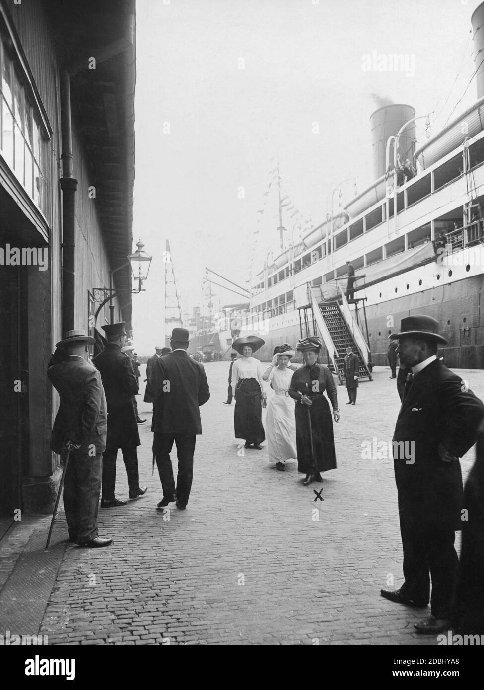 'Princess Irene of Prussia (nee Hesse-Darmstadt, wearing a black dress in the centre of the picture) was a prominent guest of the last Prinz-Heinrich-Fahrt in 1911, which had been sponsored by her husband Henry of Prussia. Here she is in Bremerhaven. On the right is the imperial mail steamer ''Grosser Kurfuerst'' of the Norddeutscher Lloyd, aboard which Henry of Prussia was also in Southampton during this voyage.' Stock Photo