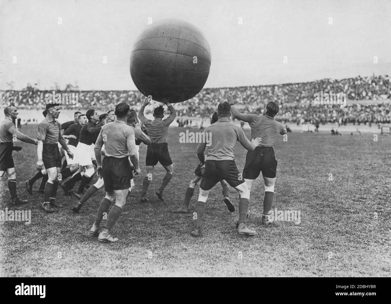 Pushball is played for the first time at the anniversary sports festival in the stadium. A 1.8 meter high and 23 kg heavy ball should be brought into the opponent's goal, whereby almost all techniques are allowed. In the photo the men crowd around the pushball, which they hold above their heads. The year 1924 is considered a sports year, as the Olympic Games, the Nordic World Ski Championships and the Chess Olympics are all taking place. Stock Photo