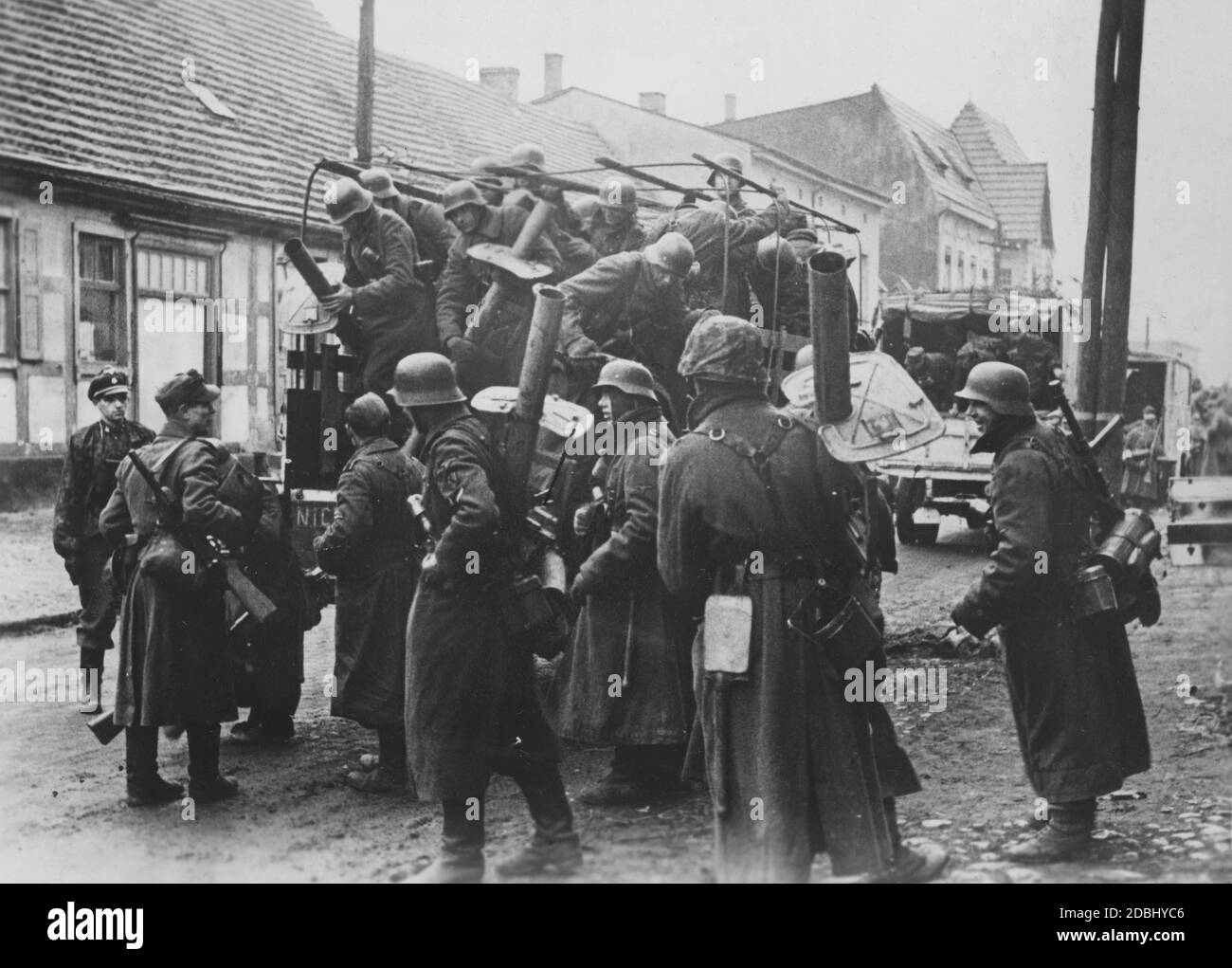 Soldiers of the Waffen-SS are getting off their trucks in a village in Pomerania. They are armed with bazookas of the type Panzerschreck. Photo: Kirsch. Stock Photo