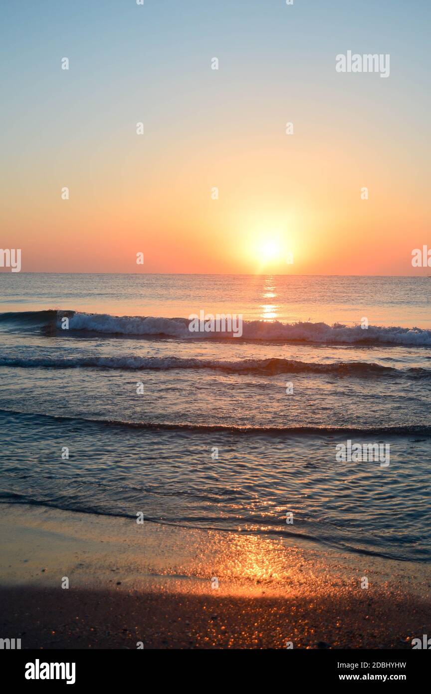 Beautiful summer landscape, sunset at the beach, sparkly sand and waves ...