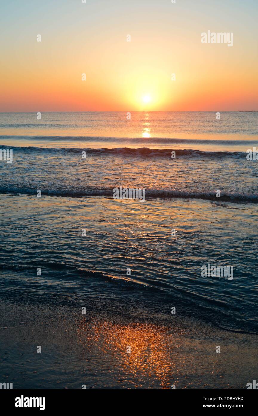 Beautiful summer landscape, sunset at the beach, sparkly sand and waves ...