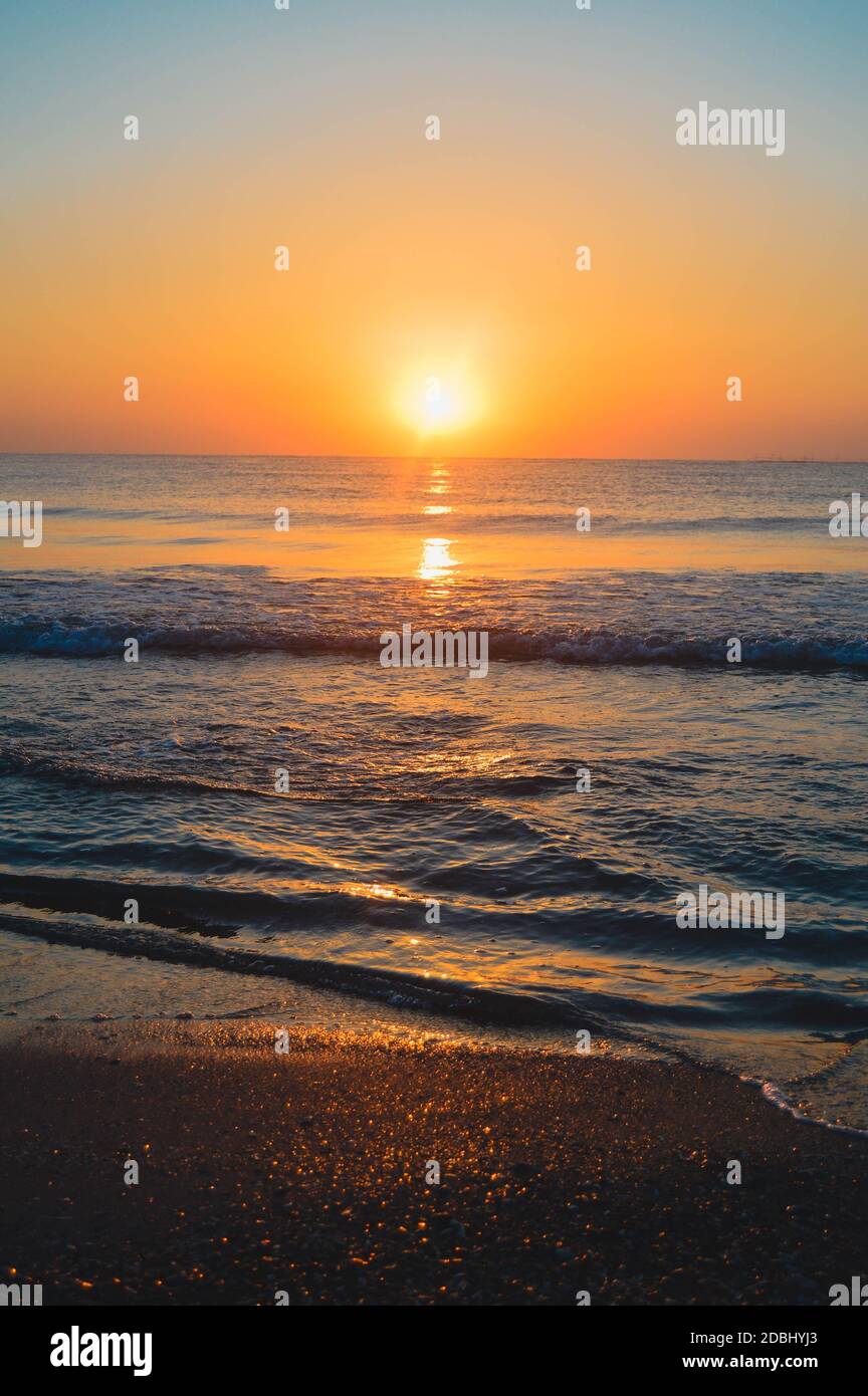 Beautiful summer landscape, sunset at the beach, sparkly sand and waves ...