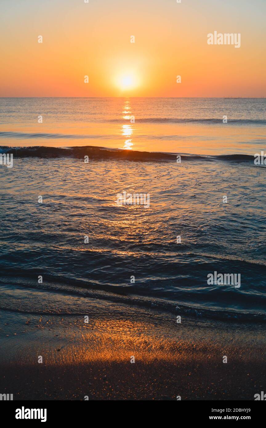 Beautiful summer landscape, sunset at the beach, sparkly sand and waves ...