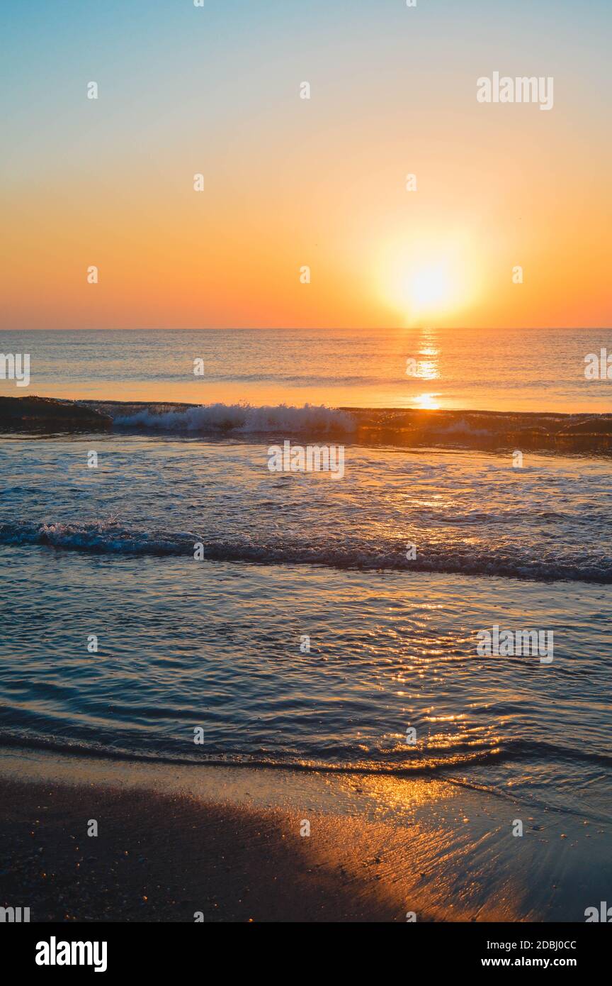 Beautiful summer landscape, sunset at the beach, sparkly sand and waves ...