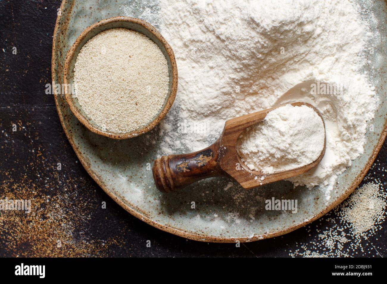 Raw fonio flour and seeds with a spoon on dark background ещз мшуц. Alternative flour Stock Photo