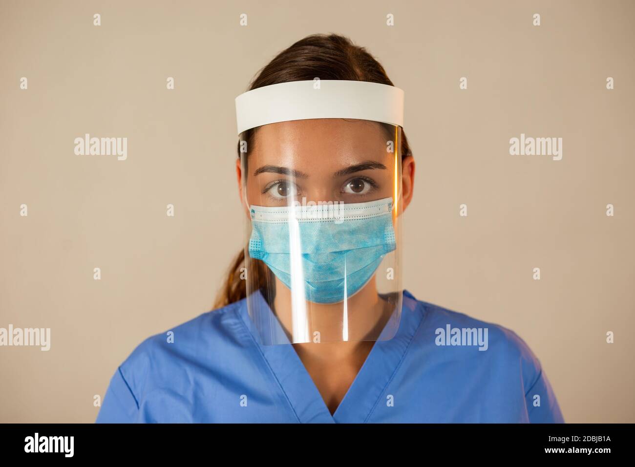 Caucasian female with attached face shield with light background. Stock Photo