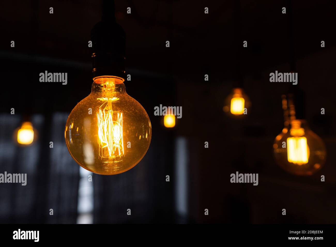 Closeup of incandescent light bulbs hanging in the dark room