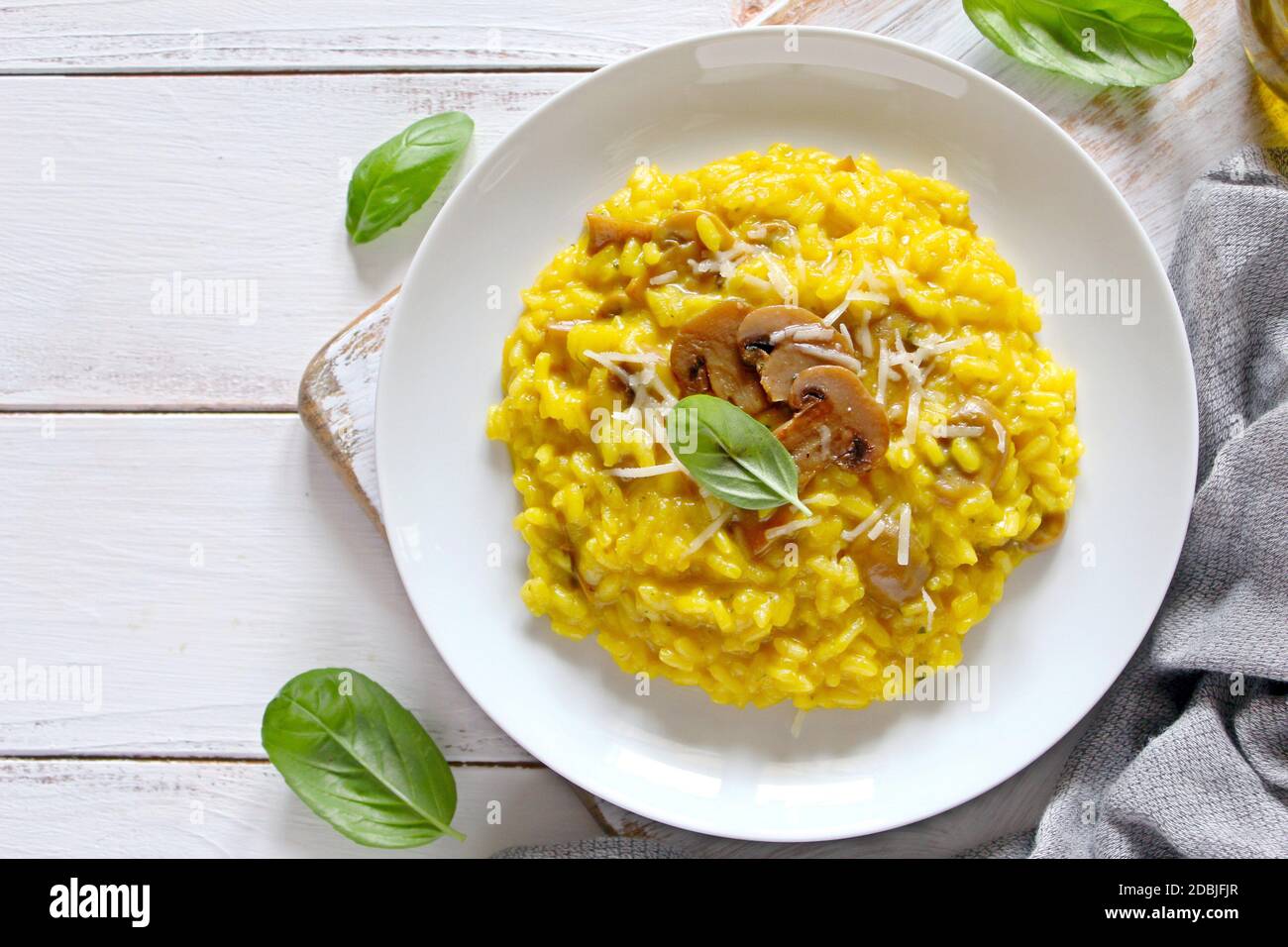 Traditional Italian risotto with mushrooms, saffron and parmesan cheese on wooden background. Top view. Stock Photo