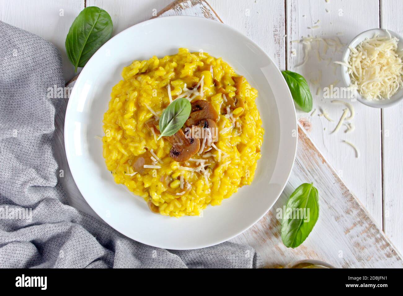 Traditional Italian risotto with mushrooms, saffron and parmesan cheese on wooden background. Top view. Stock Photo
