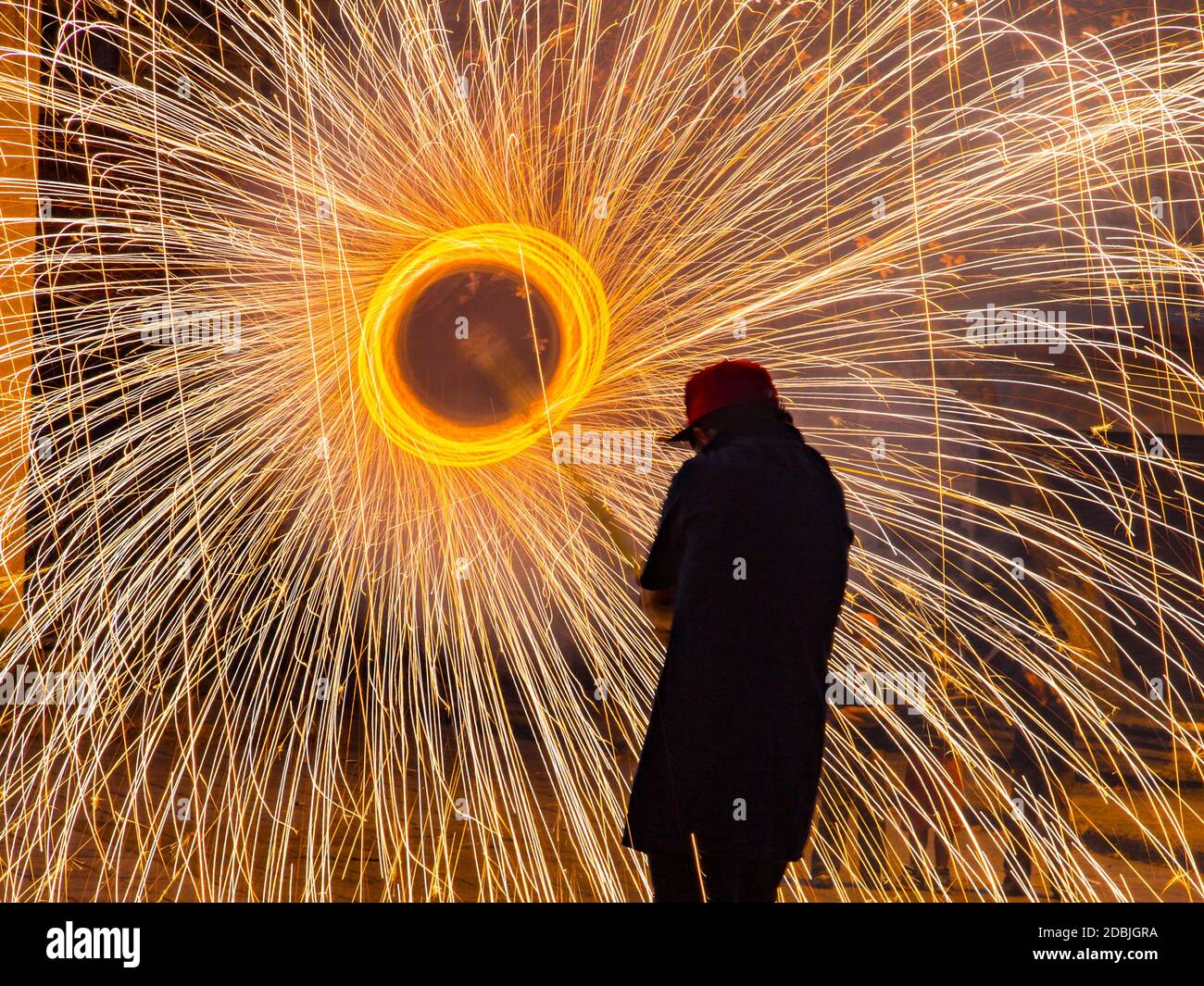 This man is holding a 6 foot pole with spinning fireworks on the end. He  ducks his head to avoid sparks on his face in Cuenca, Ecuador Stock Photo -  Alamy