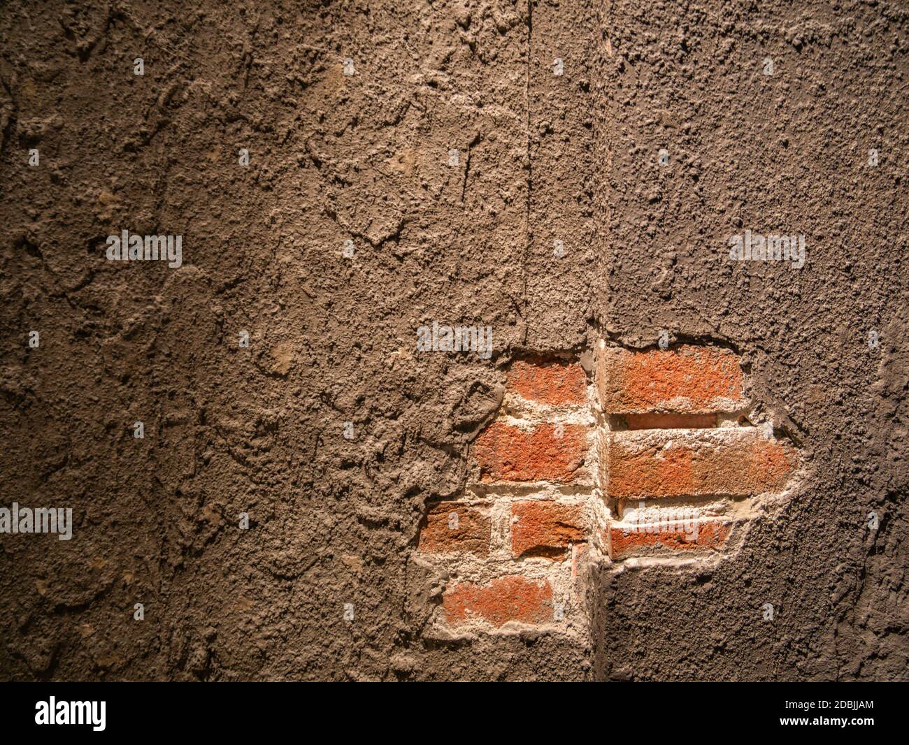 A fallen plaster on a red brick wall in an old building Stock Photo