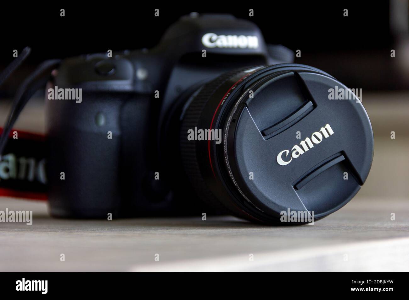 Brecht, Belgium - April 30 2020: A closeup frontal portrait of a canon eos 7D mark II camera lying on a table with an L lens and the lens hood contain Stock Photo