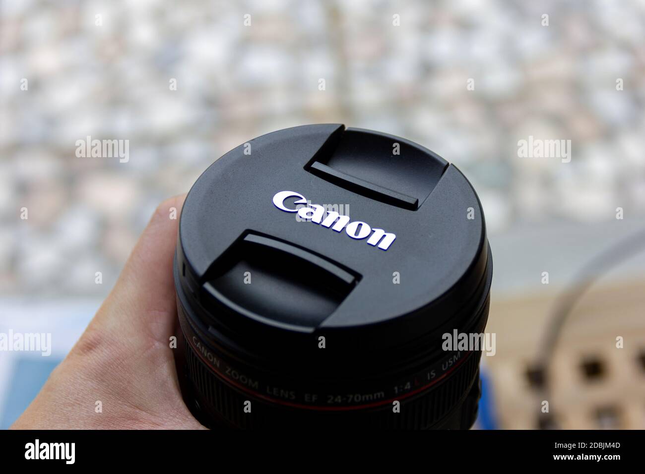 Brecht, Belgium - June 20 2020: A portrait of someone holding a canon L lens with a lens cap with the company logo attached to it. Stock Photo