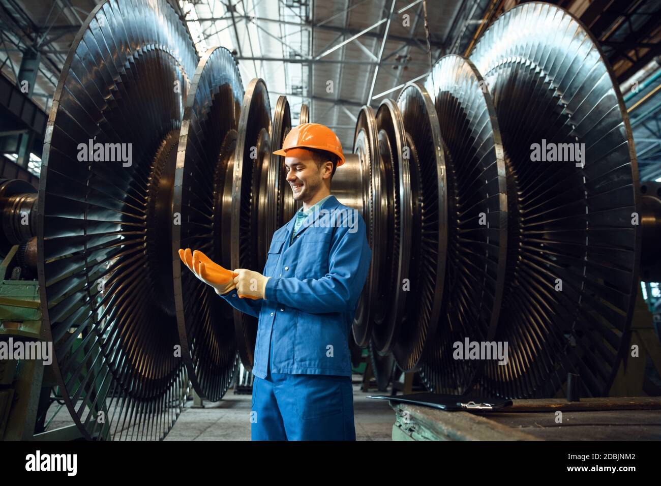 Manufacturing Vane Male worker checks turbine impeller vanes on factory. Industrial ...