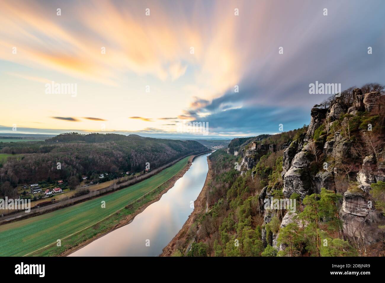 Elbe Sandstone Mountains - View from the 'Bastei' in west direction following the river Elbe, evening light with colorful illuminated clouds, soft foc Stock Photo