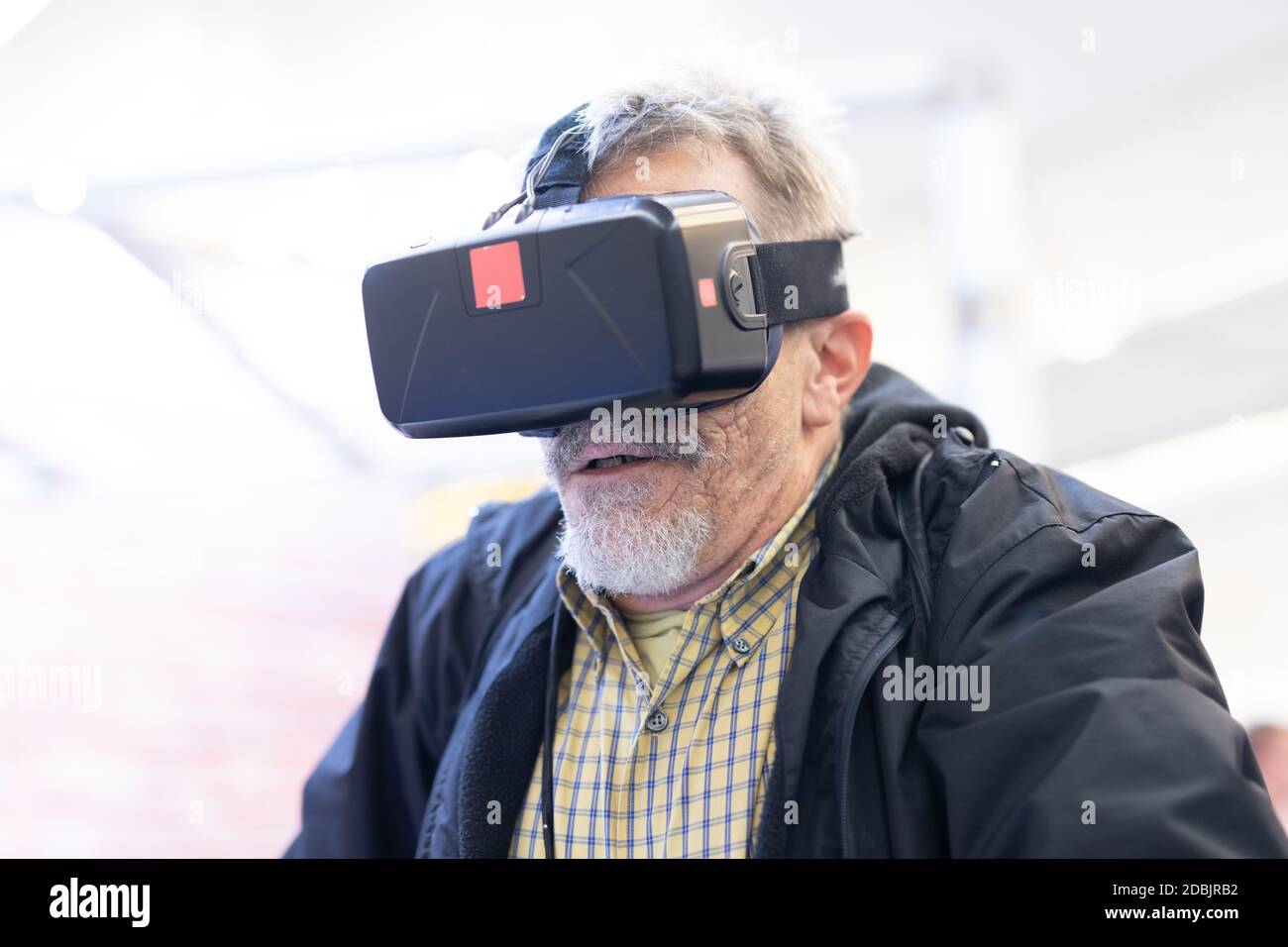 Senior man wearing virtual reality headset glasses. Virtual reality presentation. Stock Photo