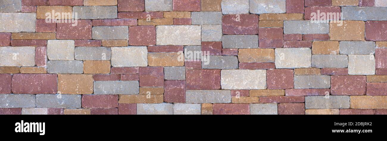 Colored wall made of square, gray, ocher and red stones Stock Photo