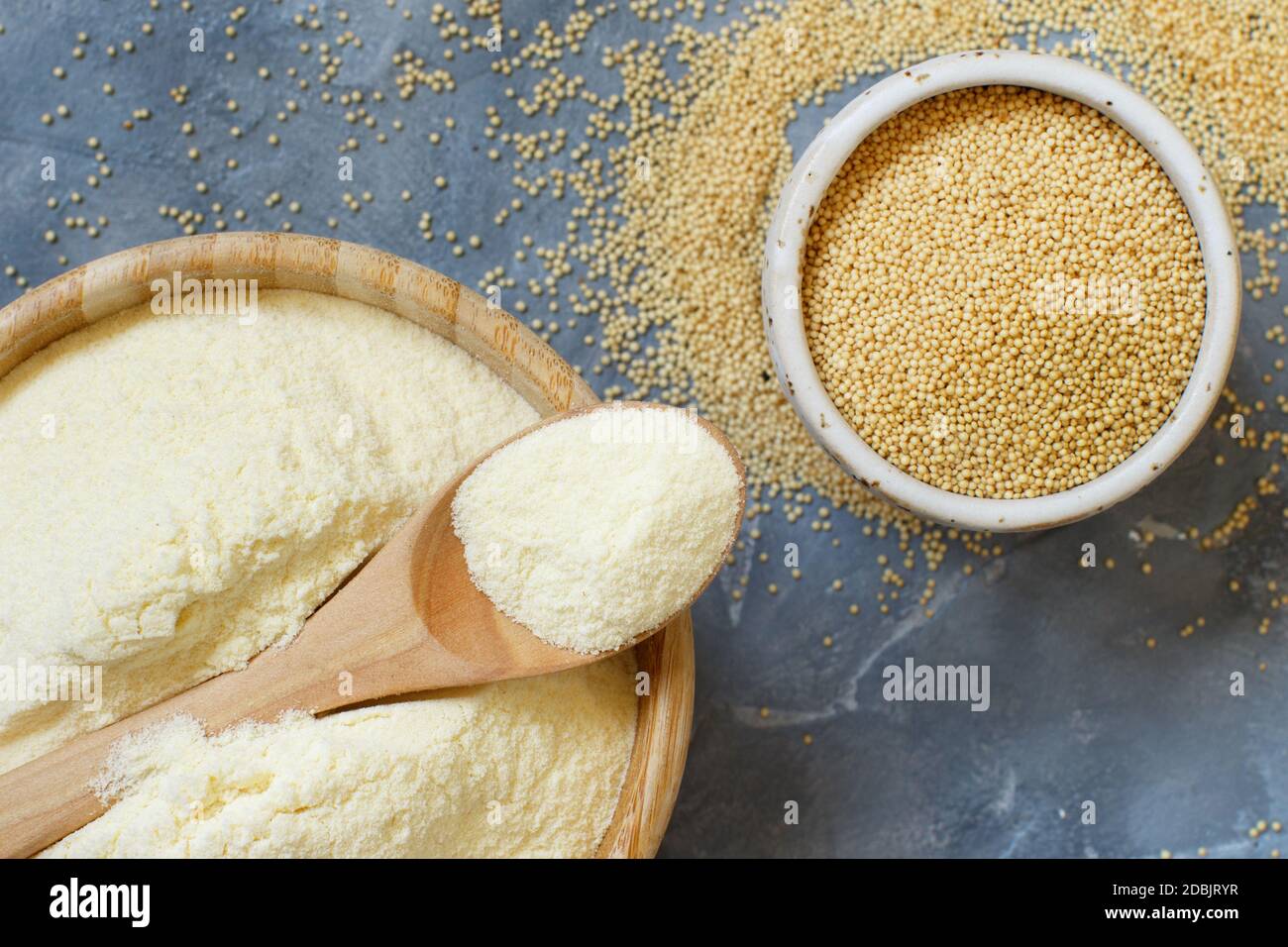 Bowl of raw Amaranth flour with a spoon and bowl of Amaranth seeds on a grey table top view Stock Photo