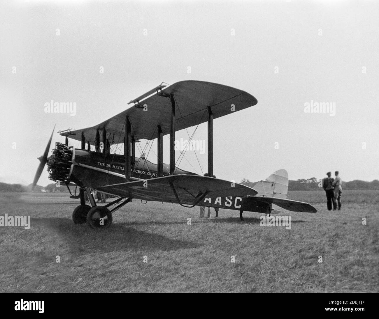 Vintage black and white photograph of a De Havilland DH.9J aeroplane, registration G-AASC, belonging to the De Havilland School Of Flying, at an airfield in England in 1930. two men in the photo. Stock Photo