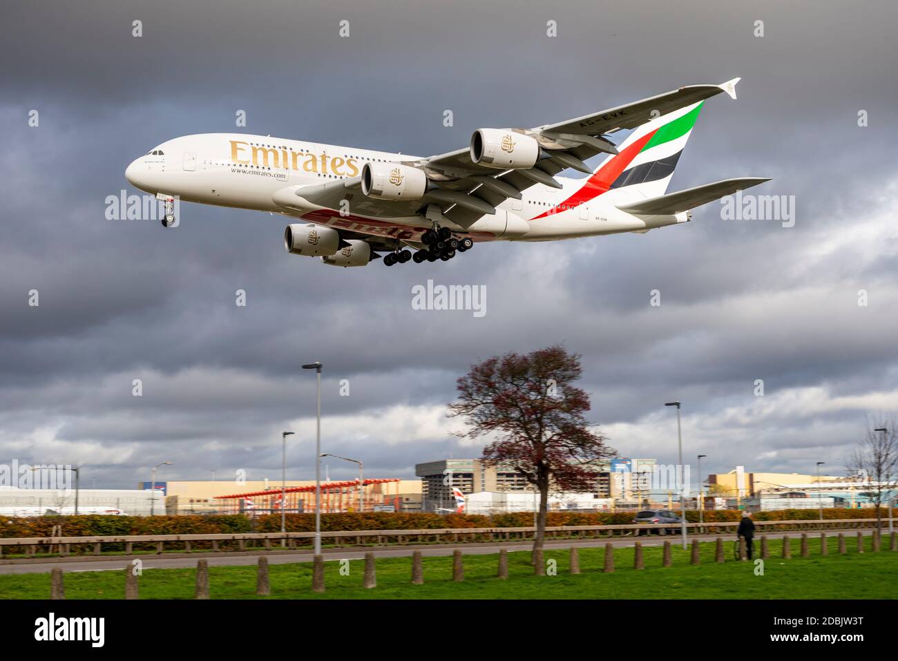 Emirates Airbus A380 super jumbo airliner jet plane landing at London Heathrow Airport, UK, passing over the A30 Great South West Road under clouds Stock Photo