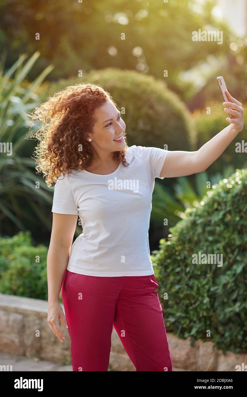 Young redhead woman using mobile phone Stock Photo