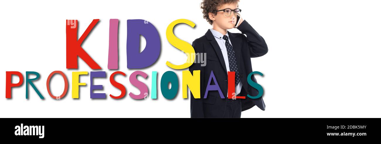 curly boy in suit and glasses talking on smartphone near kids professionals lettering on white, banner Stock Photo