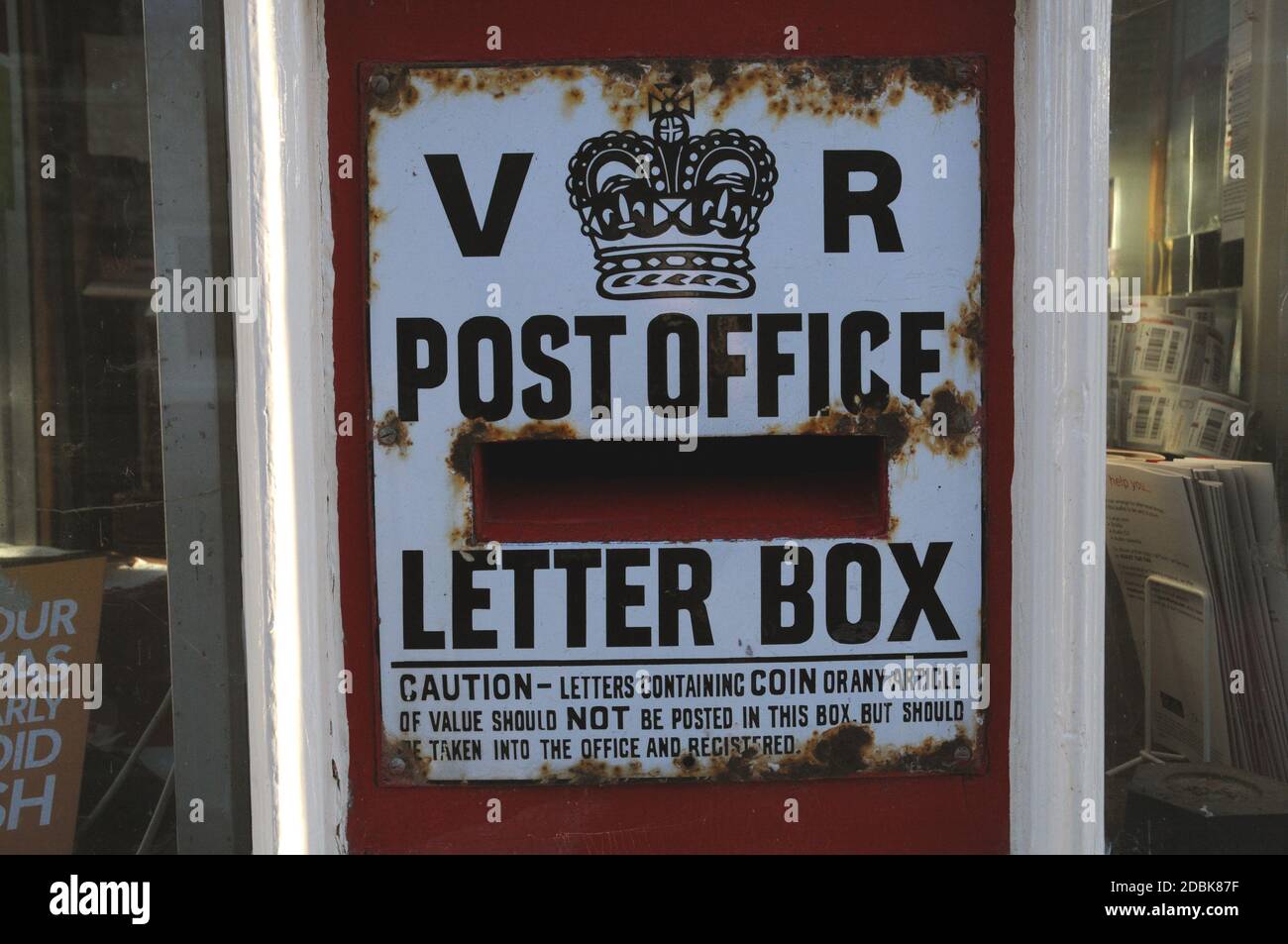 The old post box, dating from the reign of Queen Victoria, set into the wall of the village store and post office in the East Sussex village of Glynde Stock Photo