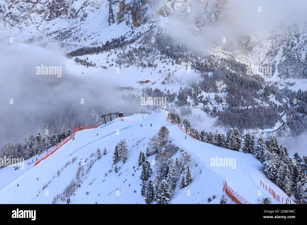View of two ski slopes in winter and valley, with some clouds around, Val Gardena, Dolomites, Italy Stock Photo