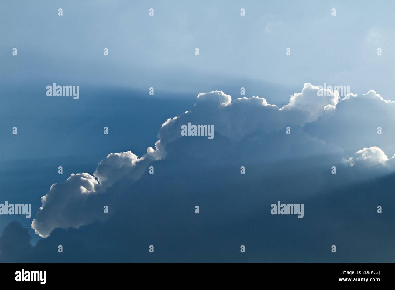 sunlight shining through layers of clouds Stock Photo