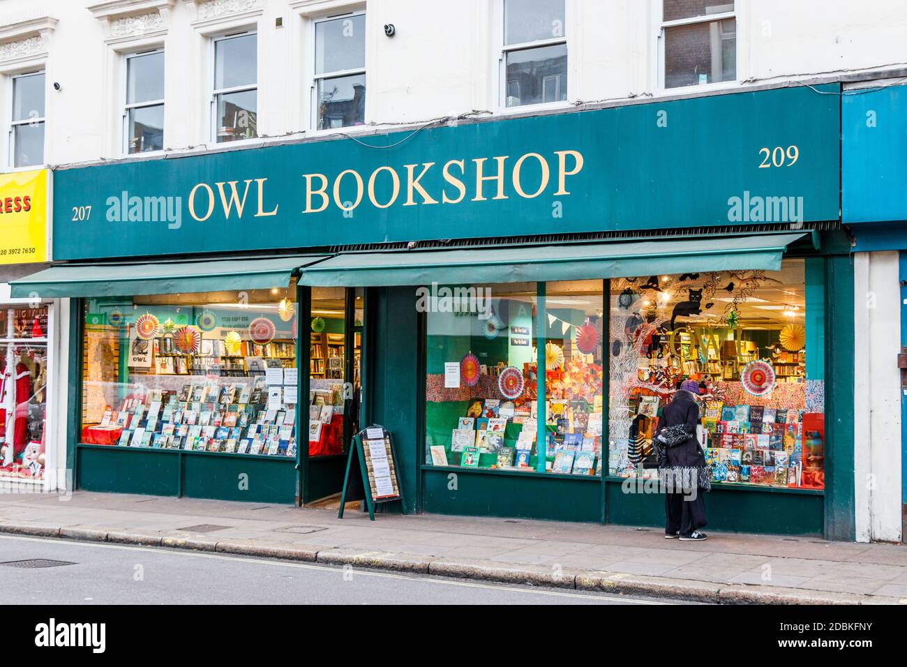 A woman browses in the window of the Owl Bookshop in Kentish, London, UK Stock Photo