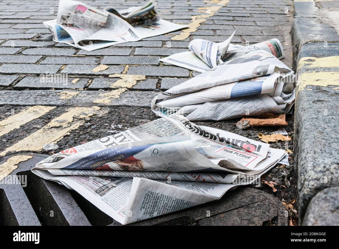 Concept image of discarded tabloid newspapers in the road, signifying the gutter press Stock Photo
