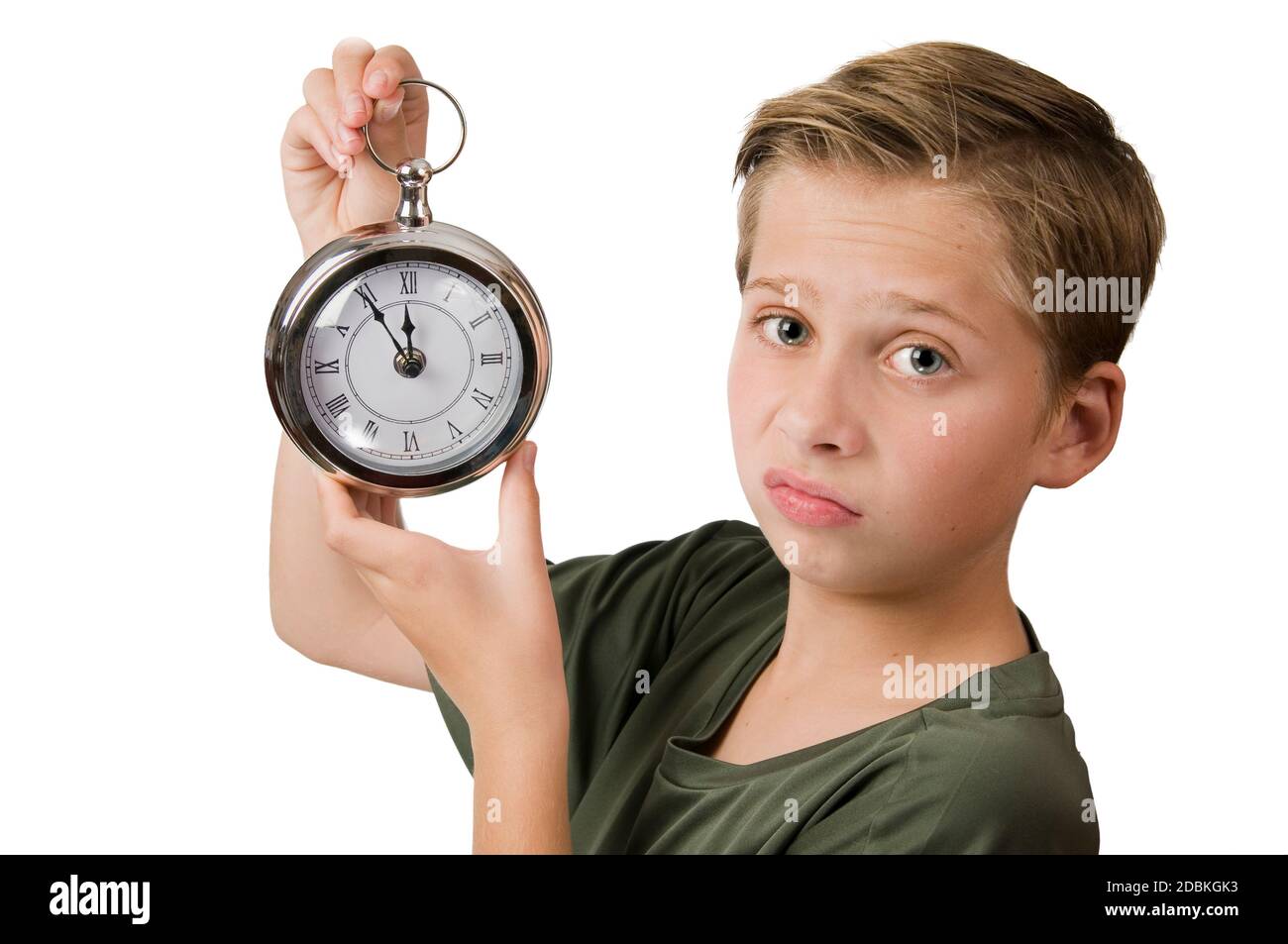 Lateral head-and-shoulders view of a 12-year-old Caucasian boy with his right hand holding an oversized pocket watch with a pointer 5 minutes to 12 an Stock Photo