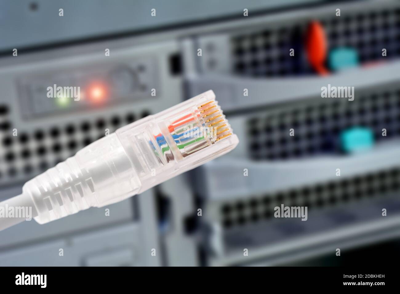 Conceptual shot of data connection with rj45 patch cable in foreground and disk array in background. Stock Photo