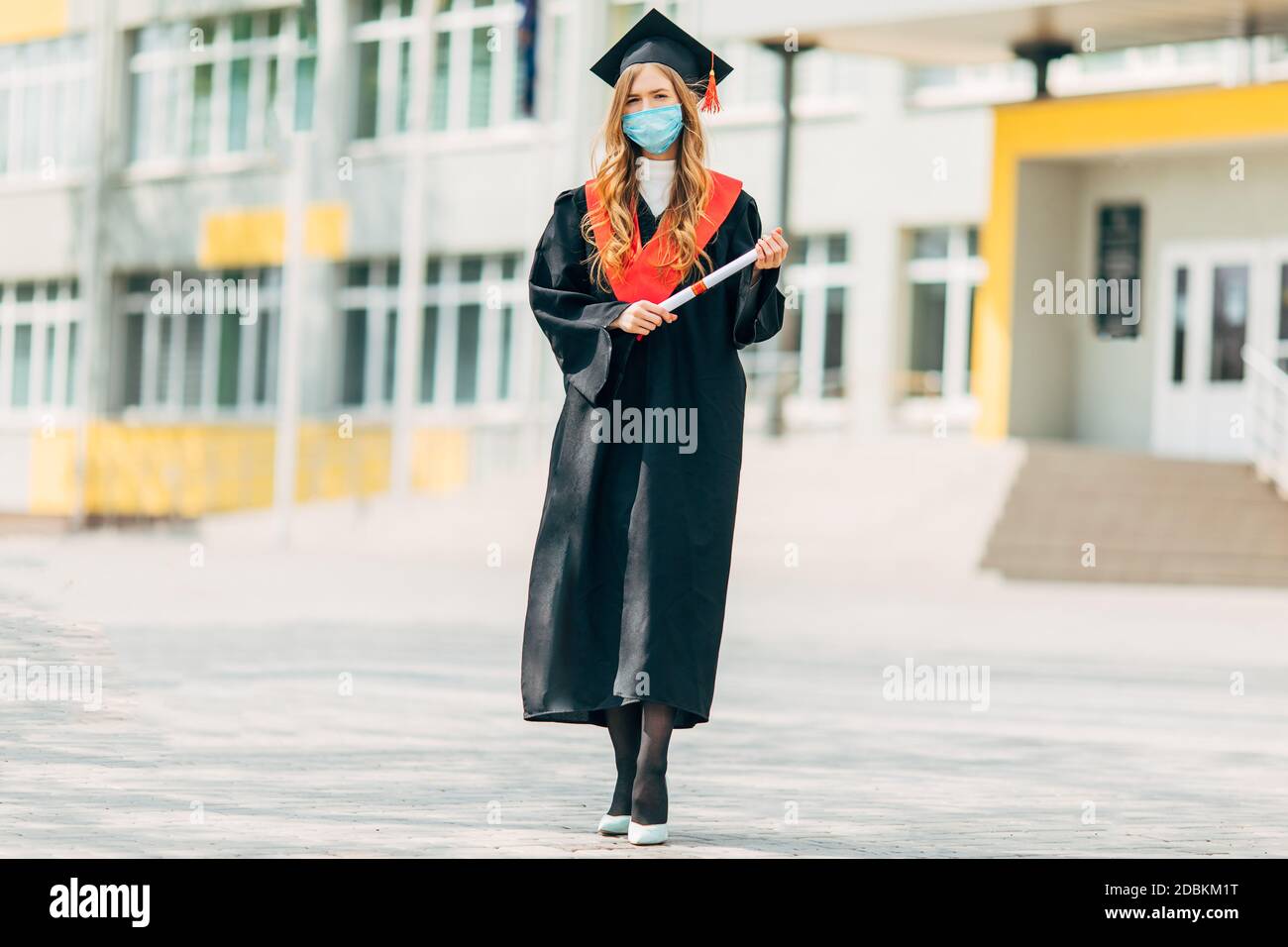 A female graduate student in a protective medical mask, in a black graduation  dress, with a diploma in her hands. Graduation ceremony concept, quarant  Stock Photo - Alamy