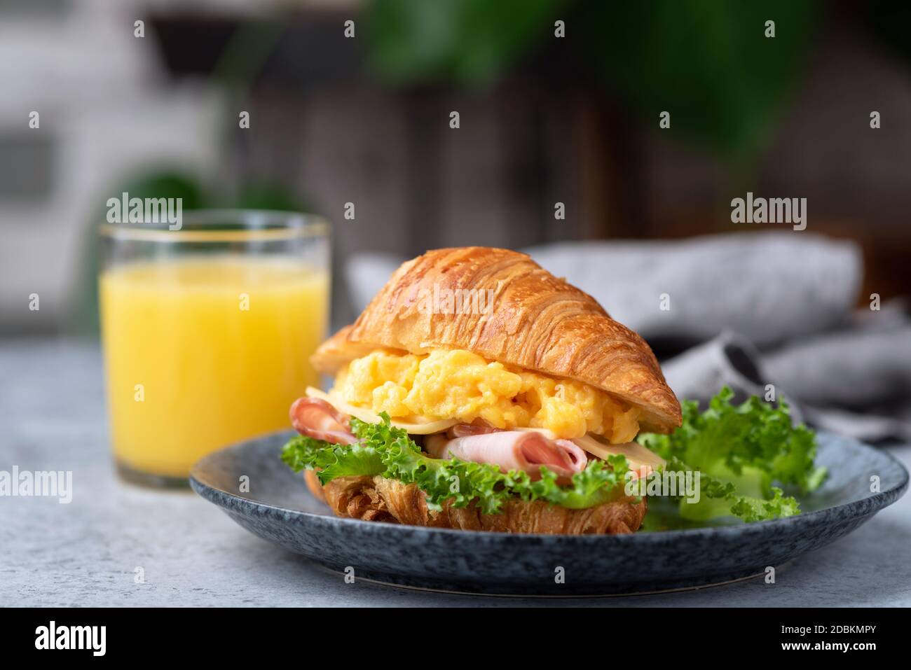 Delicious Croissant Sandwich With Ham Cheese And Scrambled Eggs On Plate Served With Glass Of Orange Juice Stock Photo Alamy