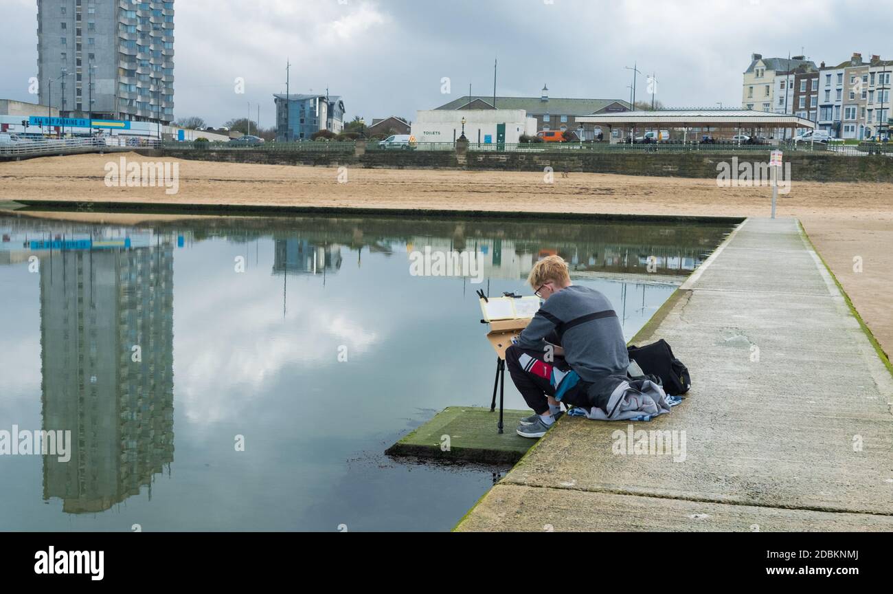 Man painting on the tidal swimming pool on the beach off Marine Terrace, Margate, Kent Stock Photo