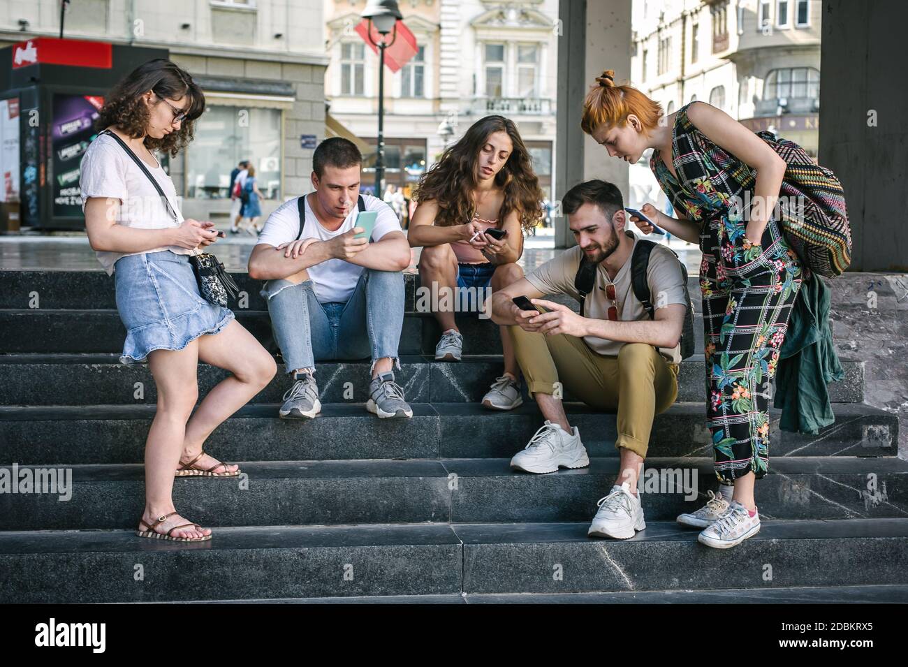 Using Internet With Friends Photo Group of friends using smartphones together. Young people addiction to ...