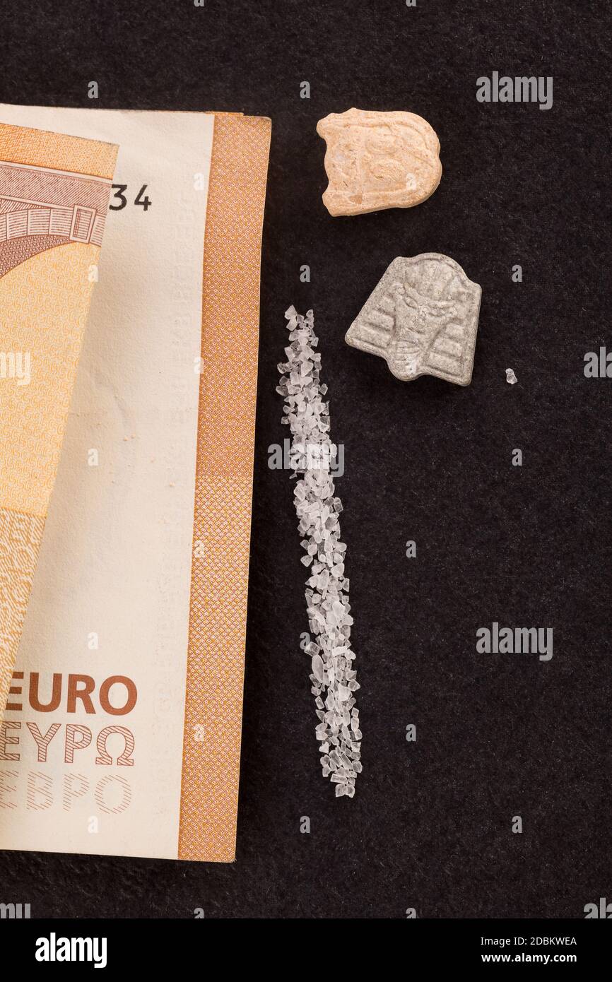 Dealing drugs. Ecstasy pills, MDMA crystal and money. Stock Photo