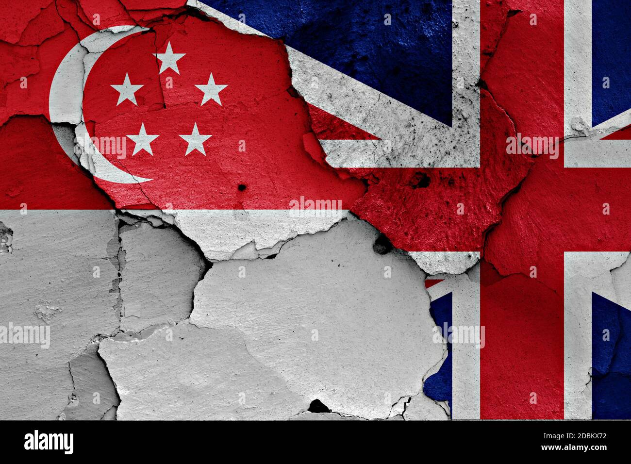 flags of Singapore and UK painted on cracked wall Stock Photo
