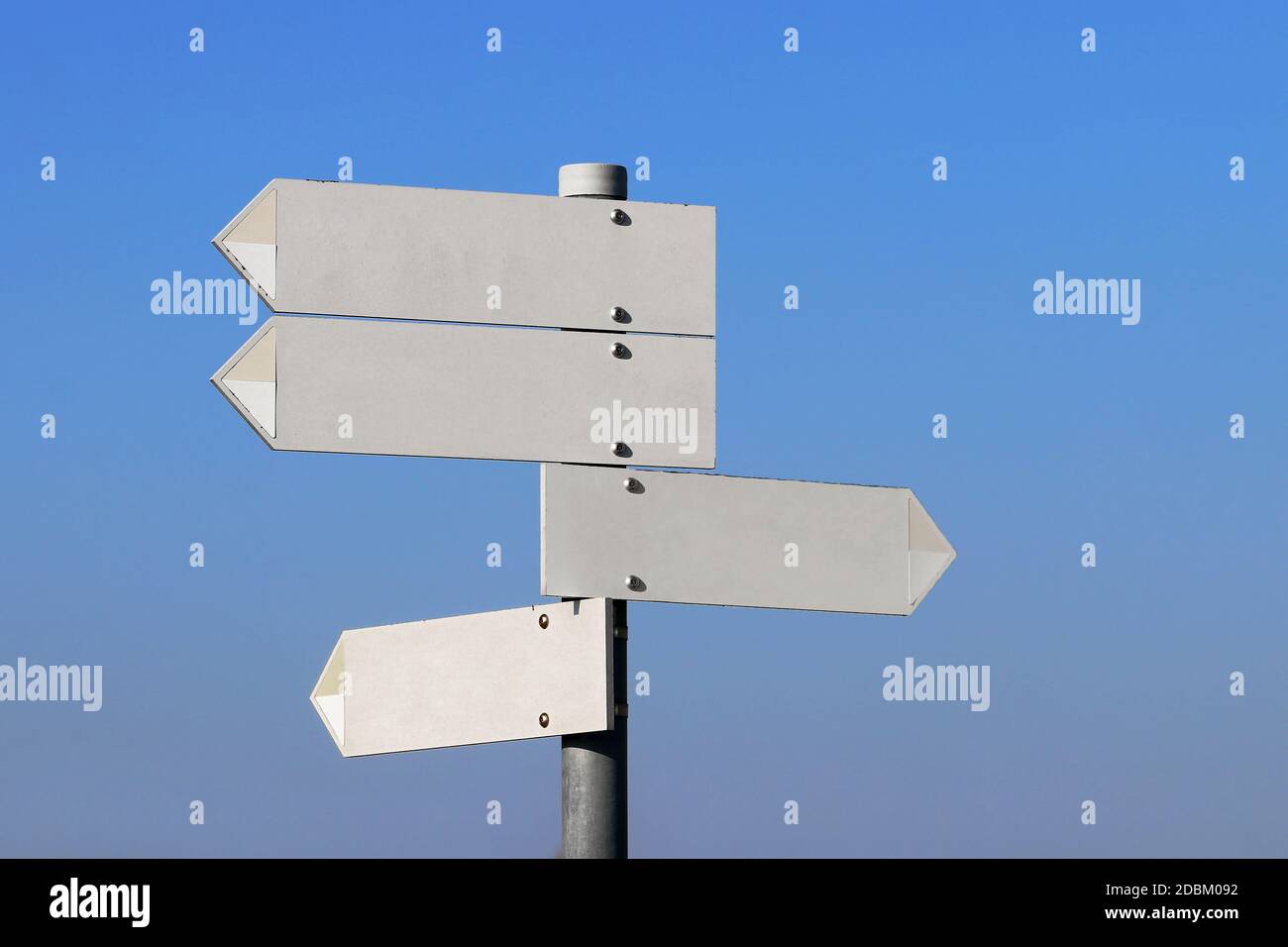 Empty directional signs in front of a blue sky Stock Photo