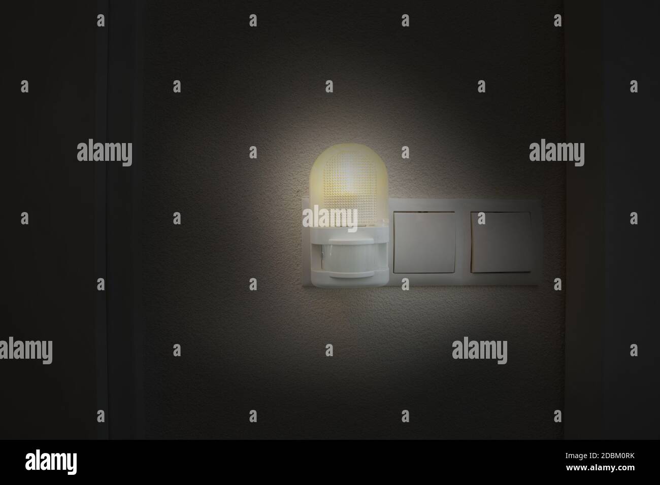 Night light plug in white socket on white wall turns on automatically