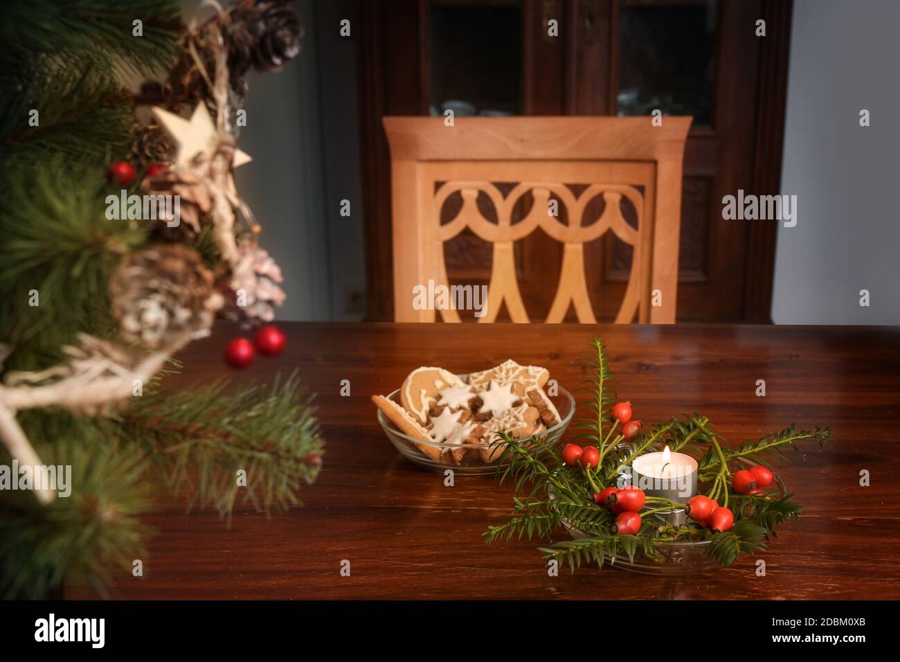 Empty chair at a table with burning candle, christmas decoration and