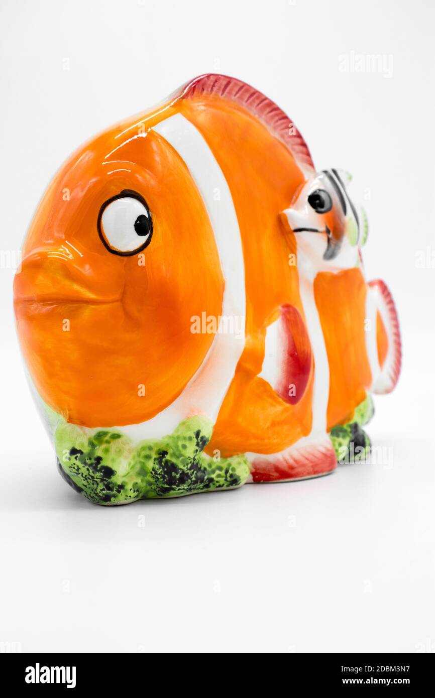Porcelain piggy bank in the shape of a clown fish on a white background Stock Photo