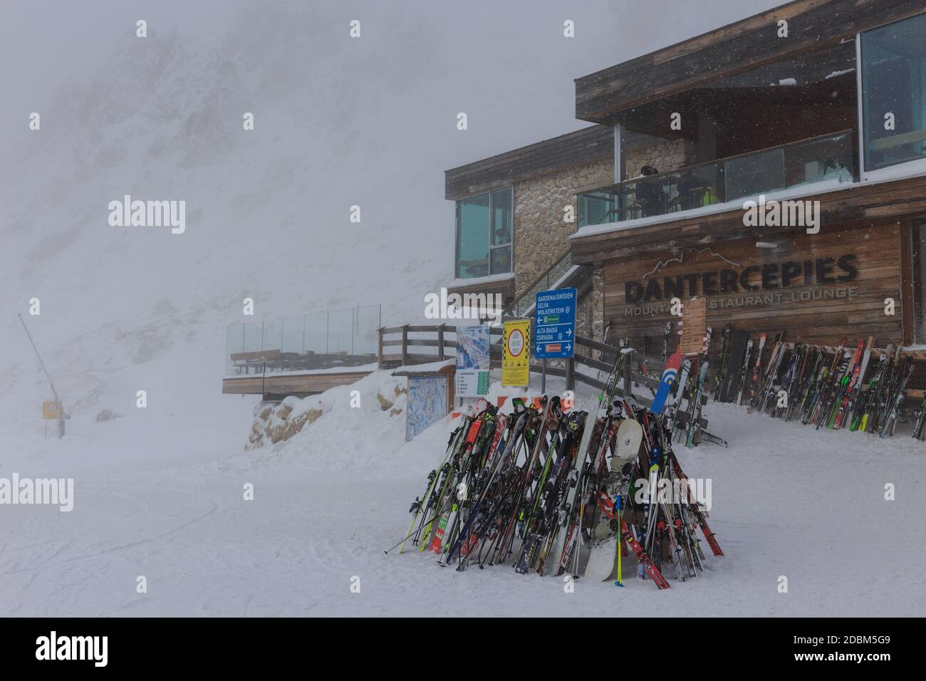A group of skis piled up outside Danterpieces restaurant on a foggy day, Val Gardena, Dolomites, Italy Stock Photo